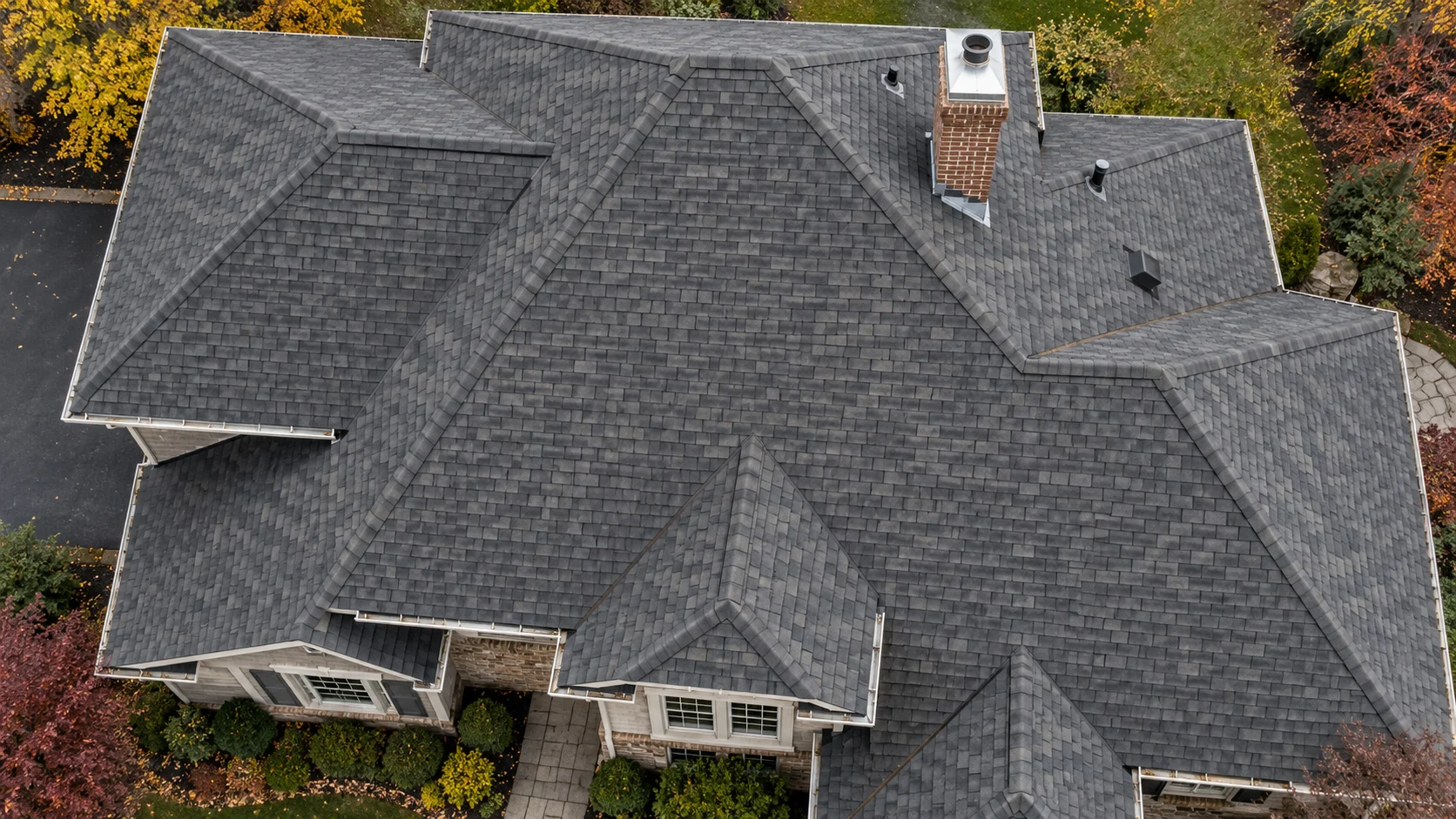 Illustrative overhead roof view showing shingles, a chimney and roof edges